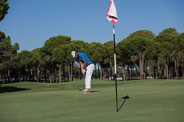 Image showing golf player hitting shot at sunny day