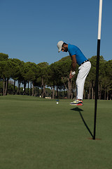 Image showing golf player hitting shot at sunny day