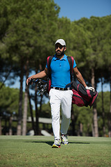 Image showing golf player walking and carrying bag