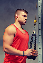 Image showing man flexing muscles on cable machine gym