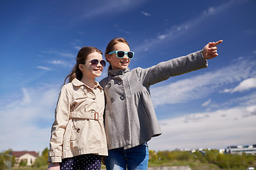 Image showing happy little girls hugging and pointing finger