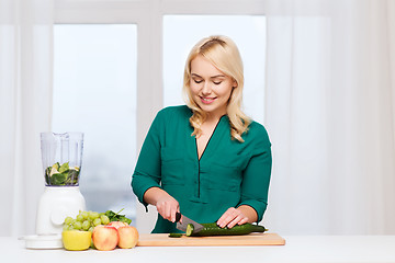 Image showing smiling woman with blender cooking food at home