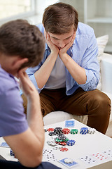 Image showing close up of male friends playing cards at home