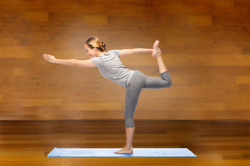 Image showing woman making yoga in lord of the dance pose on mat