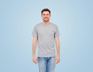 Image showing smiling young man in gray t-shirt and jeans