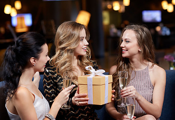 Image showing happy women with champagne and gift at night club