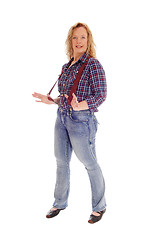 Image showing A blond woman standing in jeans and suspender.