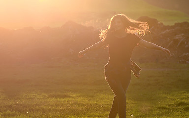 Image showing Girl jump against beautiful sunset in forest