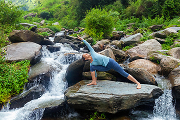 Image showing Woman practices yoga asana Utthita Parsvakonasana outdoors