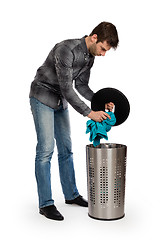 Image showing Young man putting a dirty towel in a laundry basket