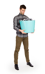 Image showing Full length portrait of a young man holding a laundry basket