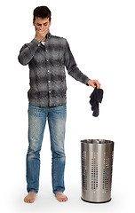 Image showing Young man putting dirty socks in a laundry basket