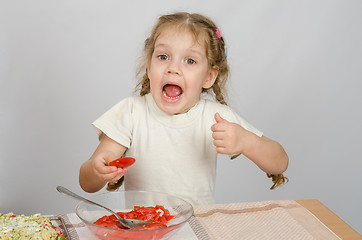 Image showing Little girl with mouth open holding a large slice of tomato