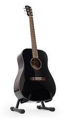 Image showing Black acoustic guitar on stand, isolated