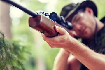 Image showing soldier or hunter shooting with gun in forest