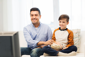 Image showing smiling father and son watching tv at home