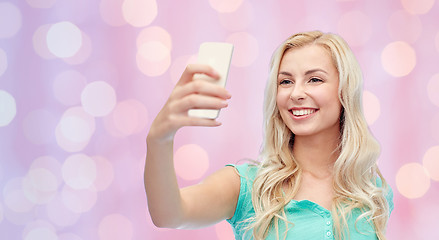 Image showing smiling young woman taking selfie with smartphone