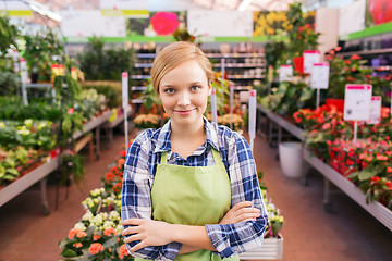 Image showing happy woman with flowers in greenhouse