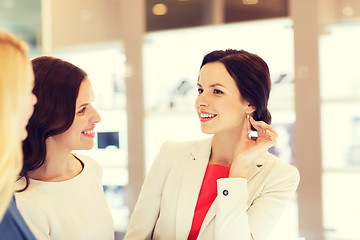 Image showing happy women choosing earrings at jewelry store