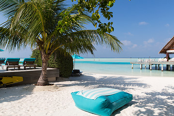 Image showing parasol and sunbeds by sea on maldives beach