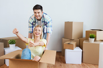 Image showing happy couple having fun with boxes at new home