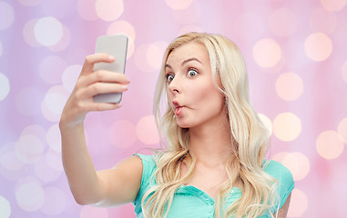 Image showing funny young woman taking selfie with smartphone