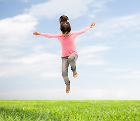 Image showing happy little girl jumping in air