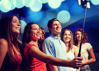 Image showing friends with smartphone taking selfie in club