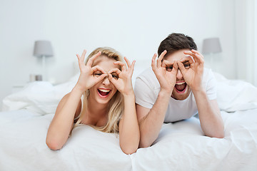 Image showing happy couple lying in bed at home