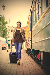 Image showing woman with luggage rushing on train