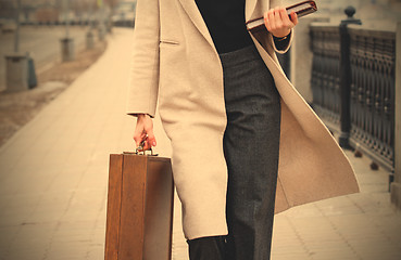 Image showing woman in a light coat, with a wooden case