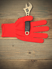 Image showing red glove and a pipe wrench