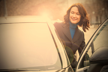 Image showing smiling middle-aged woman sits in the car 