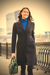 Image showing joyful woman in a dark coat 