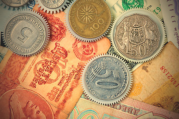 Image showing coin gear on the background of banknotes