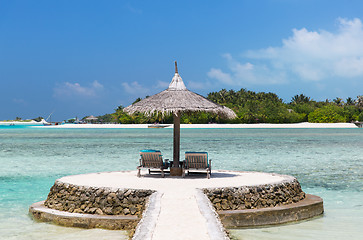 Image showing palapa and sunbeds by sea on maldives beach