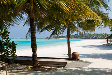 Image showing bungalow huts in sea water on exotic resort beach