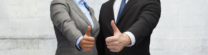 Image showing businessman and businesswoman showing thumbs up