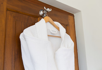 Image showing close up of white bathrobes on wooden hanger