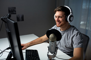 Image showing man in headset playing computer video game at home