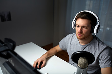 Image showing man in headset playing computer video game at home