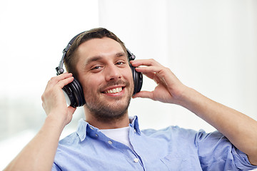 Image showing smiling young man in headphones at home