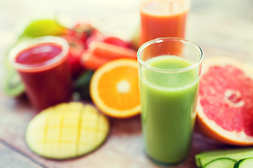 Image showing close up of fresh juice glass and fruits on table