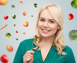 Image showing smiling young woman eating vegetable salad