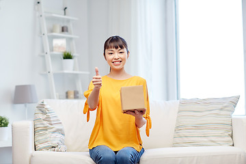 Image showing happy asian young woman with parcel box at home