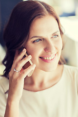 Image showing happy woman calling on smart phone at restaurant