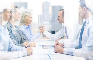 Image showing businesswoman and businessman arm wrestling