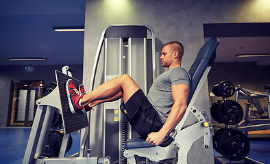 Image showing man flexing leg muscles on gym machine