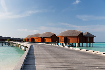 Image showing bungalow huts in sea water on exotic resort beach