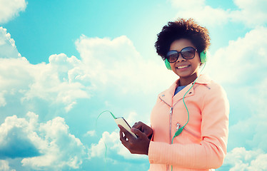 Image showing happy young woman with smartphone and headphones